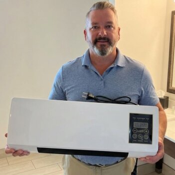 A man in his living area beside a portable cooler